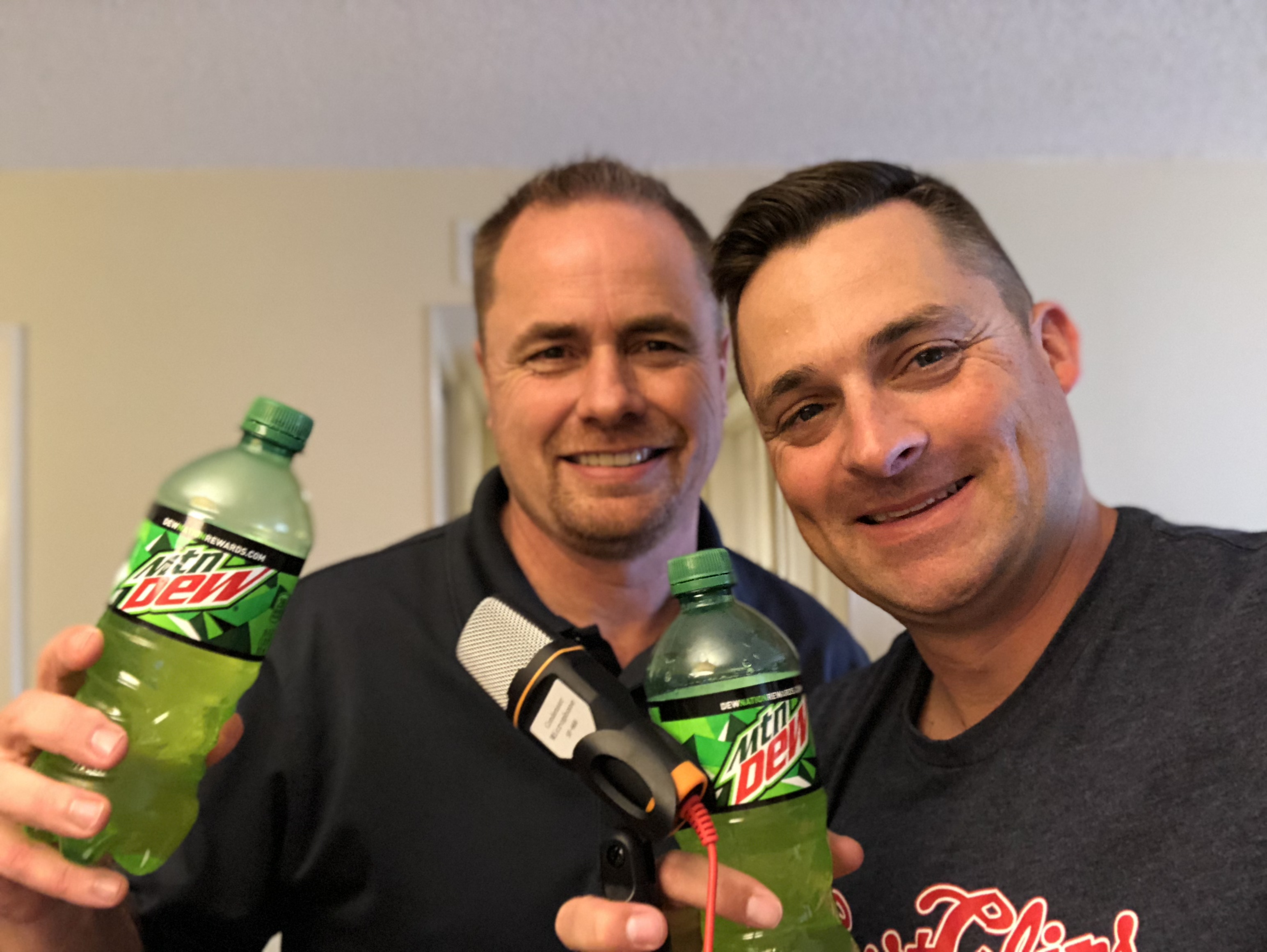 Jeff Burrough and Chad Jordand Holding a Mic and Mountain Dew